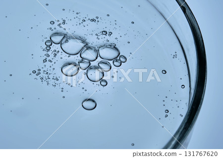 Cosmetic product, serum or shampoo, in a petri dish on a blue background. Cosmetic product, serum or shampoo, in a petri dish on a blue background. 131767620