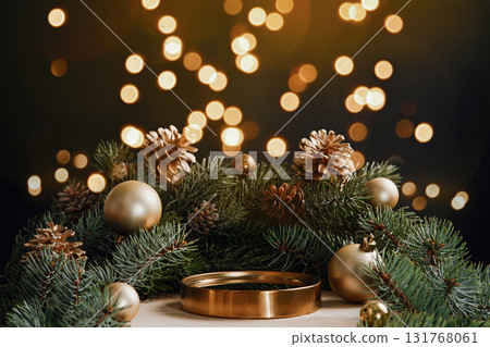 Elegant holiday background with golden podium, pine branches, cones and baubles. Warm bokeh lights and copy space for luxury product display, banners and promos. 131768061