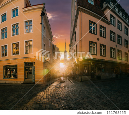 Tallinn, Estonia. Famous Old Traditional Town Hall In Sunny Evening. Sun Shining Through Old Town Narrow Streets. Famous Landmark And Popular Place. Destination Scenic. UNESCO World Heritage Site Tallinn, Estonia. Famous Old Traditional Town Hall In Sunny Evening. Sun Shining Through Old Town Narrow Streets. Famous Landmark And Popular Place. Destination Scenic. UNESCO World Heritage Site 131768235