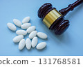 Pills and gavel symbolizing pharmaceutical regulation. 131768581
