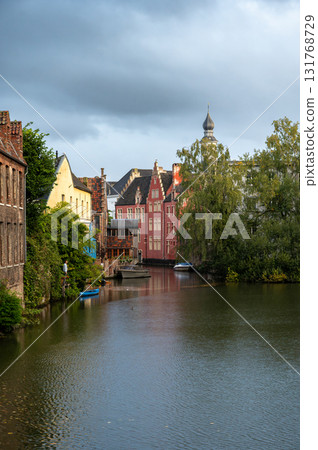 Canal-side buildings of Ghent showcasing medieval facades and soft reflections on the water. Canal-side buildings of Ghent showcasing medieval facades and soft reflections on the water. 131768729
