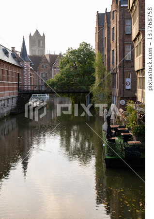 Quiet canal view with a bridge and traditional Belgian buildings in the old town of Ghent. Quiet canal view with a bridge and traditional Belgian buildings in the old town of Ghent. 131768758