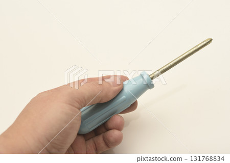 A light blue phillips screwdriver in the master's hand. A hand tool in your hands. A phillips screwdriver. 131768834