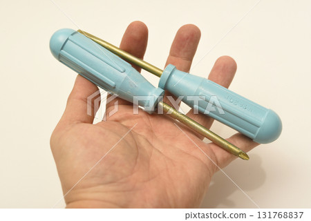 A light blue phillips screwdriver in the master's hand. A hand tool in your hands. A phillips screwdriver. A light blue phillips screwdriver in the master's hand. A hand tool in your hands. A phillips screwdriver. 131768837