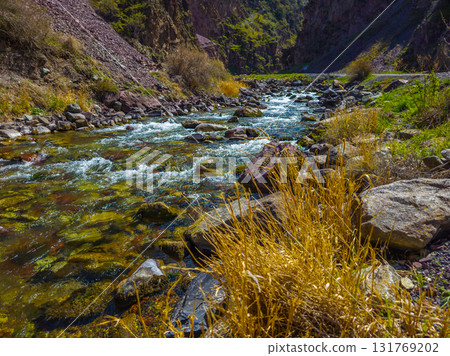 Serene river flowing over rocks in mountainous nature 131769202