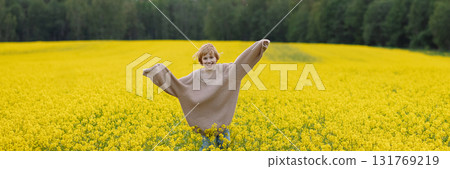 Banner smiling 9 year old girl in oversize sweater running in yellow rapeseed field Banner smiling 9 year old girl in oversize sweater running in yellow rapeseed field 131769219