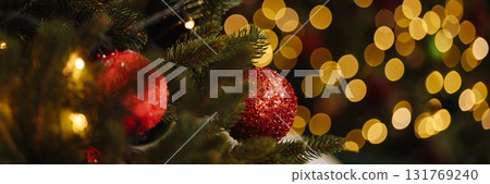 Banner red christmas baubles on fir tree branch with golden bokeh lights Banner red christmas baubles on fir tree branch with golden bokeh lights 131769240