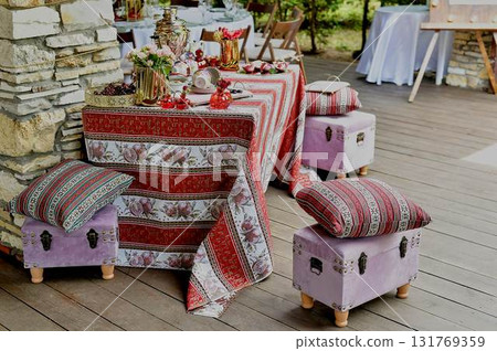 Outdoor picnic d cor on the outdoor veranda. The d cor is in the Armenian style, a tablecloth with grenades. White and red palette 131769359