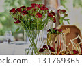 Banquet table for a wedding or anniversary. Red roses. Classic layout. Glasses and white plates. In the fresh air 131769365