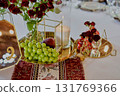 Banquet table for a wedding or anniversary. Red roses. Classic layout. Glasses and white plates. In the fresh air 131769366