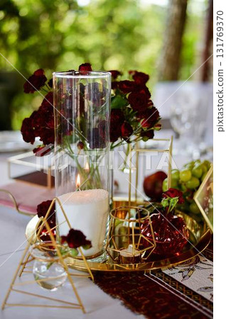 Red decorative vase in the shape of a pomegranate. Wedding table d cor. Gold and white 131769370