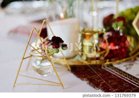 Red decorative vase in the shape of a pomegranate. Wedding table d cor. Gold and white 131769379