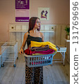 Young Man Carrying Basket of Folded Clothes 131769696