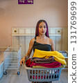Young Man Carrying Basket of Folded Clothes 131769699