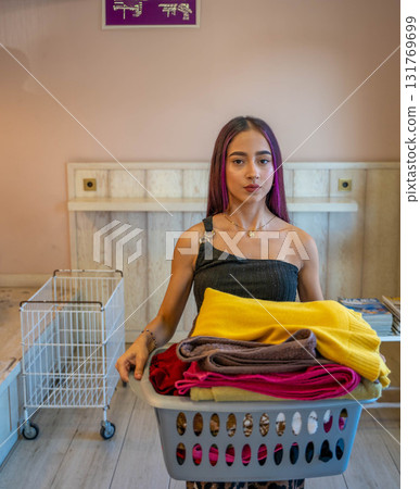 Young Man Carrying Basket of Folded Clothes Young Man Carrying Basket of Folded Clothes 131769699