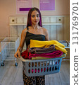Young Man Carrying Basket of Folded Clothes 131769701
