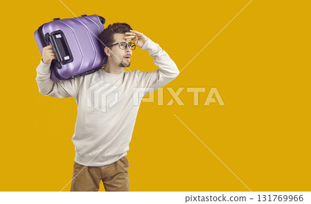 Man tourist carrying suitcase on his shoulder and looking into distance 131769966