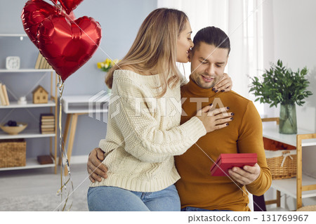 Happy loving couple with gift box hugging at home Happy loving couple with gift box hugging at home 131769967