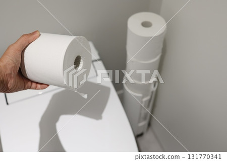 Toilet paper and storage cases piled up in the corner of the toilet. 131770341