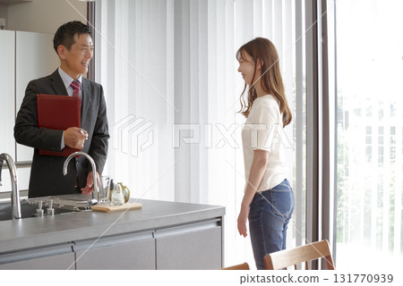 Sales staff and a woman explaining a model house 131770939