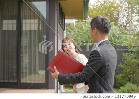 Sales staff and a woman showing a model house 131770949