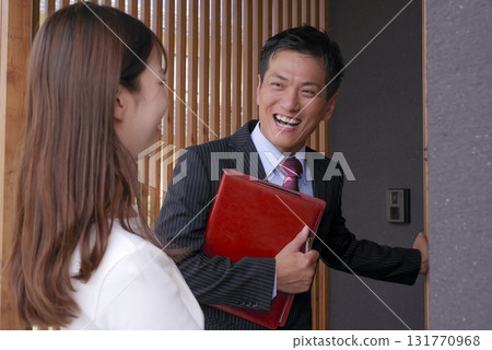 Sales staff and a woman showing a model house 131770968