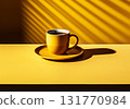 Minimalist image of yellow table with a cup of coffee on dark background 131770984