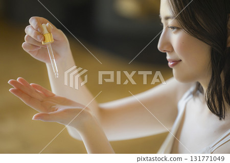 A woman looking in the mirror in the living room A woman looking in the mirror in the living room 131771049