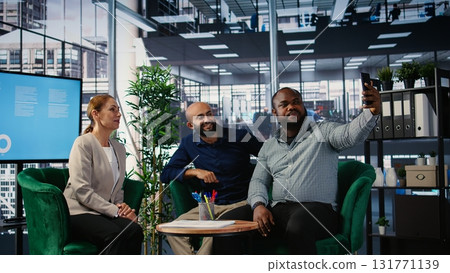 Multiethnic business people seal their partnership with a picture on social media, reaching a verbal agreement for a new international collaboration. CEOs taking photos on media platforms. Camera A. 131771139