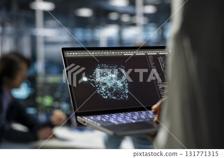Close up of data center developer using laptop, working on databases supporting AI applications. IT professional uses notebook in server hub, doing algorithms improvements with artificial intelligence 131771315