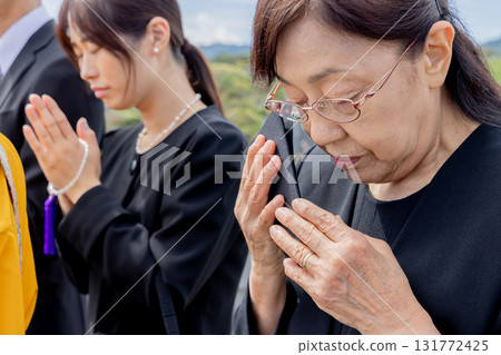 Bereaved family attending the bone-laying ceremony Bereaved family attending the bone-laying ceremony 131772425