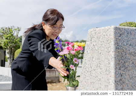 A woman who gives flowers to his grave A woman who gives flowers to his grave 131772439