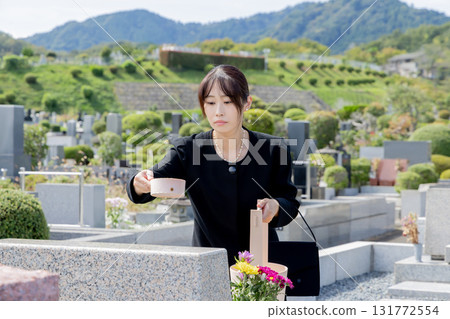 A woman cleaning a tombstone 131772554
