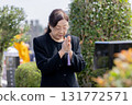 Senior woman visiting a grave 131772571