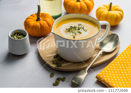 Homemade pumpkin cream soup in a bowl, bright background, fresh pumpkins 131772696