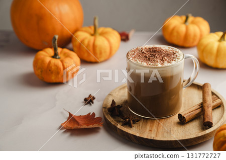 Pumpkin spice latte, coffee drink in glass cup with pumpkins, autumn hot drink 131772727