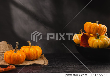 Orange pumpkins on dark background, abstract autumn, concept, copy space Orange pumpkins on dark background, abstract autumn, concept, copy space 131772735