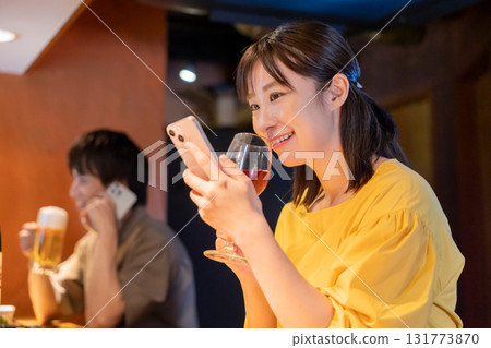 Izakaya: A woman enjoying a drink alone 131773870