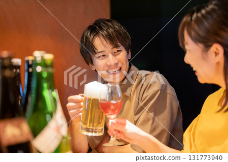Men and women drinking alcohol at an izakaya 131773940