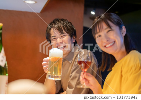 Men and women drinking alcohol at an izakaya 131773942