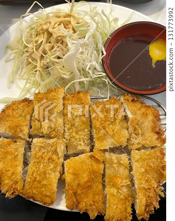 Crispy tonkatsu, a Japanese-style breaded and deep-fried pork cutlet, served with shredded cabbage and drizzled with savory sauce. A delightful balance of crunchy texture and juicy meat. Crispy tonkatsu, a Japanese-style breaded and deep-fried pork cutlet, served with shredded cabbage and drizzled with savory sauce. A delightful balance of crunchy texture and juicy meat. 131773992