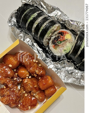 A delicious combination of kimbap and dakgangjeong. The crispy, sweet, and spicy Korean fried chicken pairs perfectly with the savory rice rolls, creating a flavorful and satisfying meal. 131774067