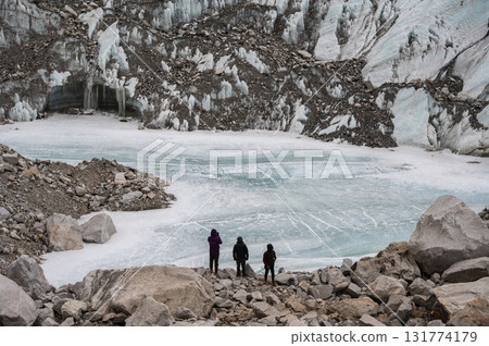 Tourist standing nealy natural pond appeared next to Everest base camp caused of Khumbu glacier melting. Climate change is causing the highest glacier on Mount Everest to melt at a rapid pace. 131774179