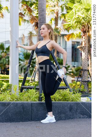 Workout begins, sport woman performs outdoor stretch exercise, fit body prepares for intense workout, embracing healthy active lifestyle in urban environment. Workout begins, sport woman performs outdoor stretch exercise, fit body prepares for intense workout, embracing healthy active lifestyle in urban environment. 131774400