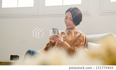 Woman operating a mobile phone Woman operating a mobile phone 131774404