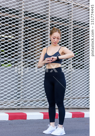 Sport woman checking data on smartwatch outdoor, monitoring fitness progress for workout exercise, fit individual focusing on healthy lifestyle pursuing ambitious sport goals. Sport woman checking data on smartwatch outdoor, monitoring fitness progress for workout exercise, fit individual focusing on healthy lifestyle pursuing ambitious sport goals. 131774445