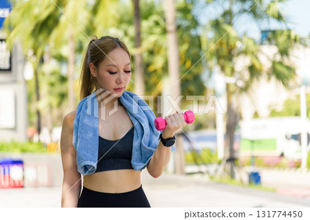 Sport woman workout outdoor fit individual ready to stretch before exercise, lifting dumbbell, building strength, promoting health, planning another stretch. 131774450