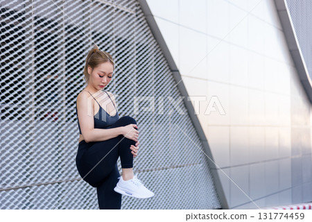 Fit woman outdoor sport exercise workout person stretch, concentrating leg movement, preparing body, completing second beneficial stretch for overall flexibility. 131774459