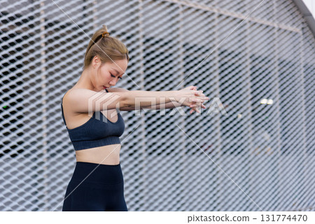 Stretch woman, showing sport exercise workout outdoor fit, preparing body for movement by intertwining fingers extending arms, then perform final stretch for flexibility and recovery. 131774470