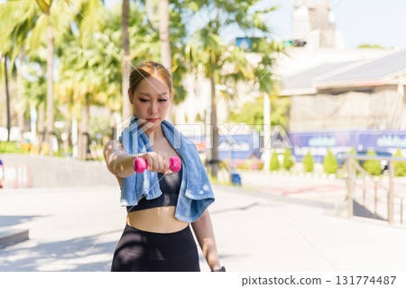 Fit woman sport exercise workout outdoor, people maintaining active lifestyle, lifting pink dumbbell, strengthening body, achieving fit physique, tropical setting. 131774487